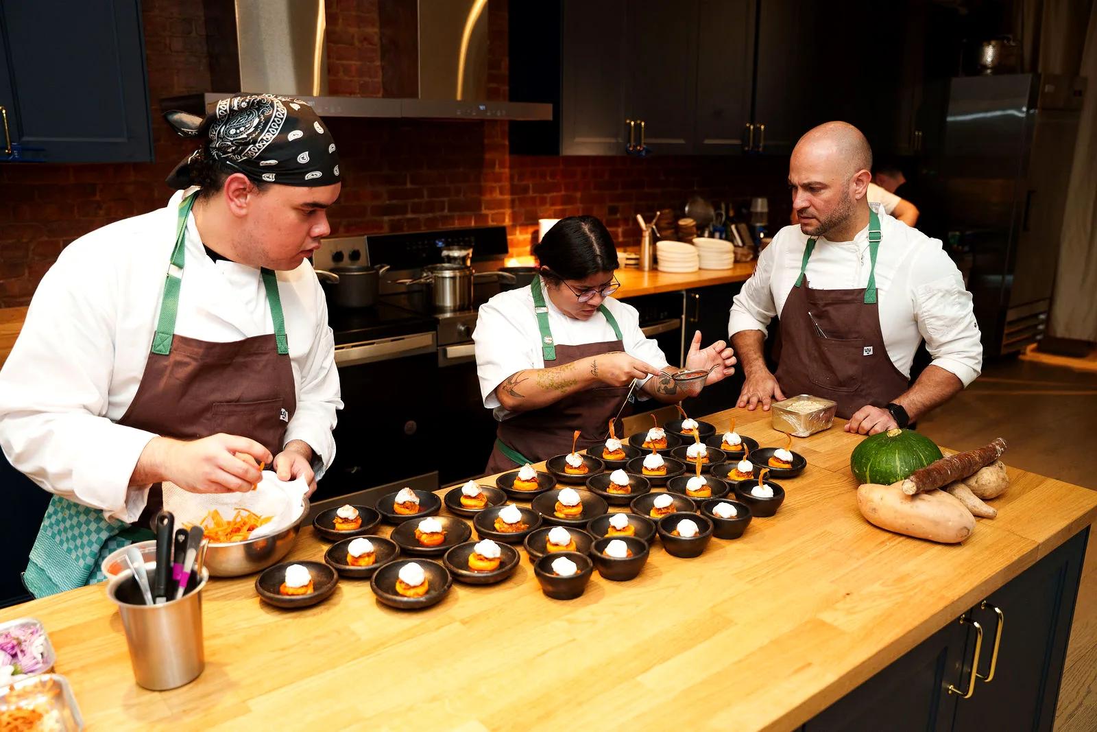 Chefs plating dishes at the kitchen island
