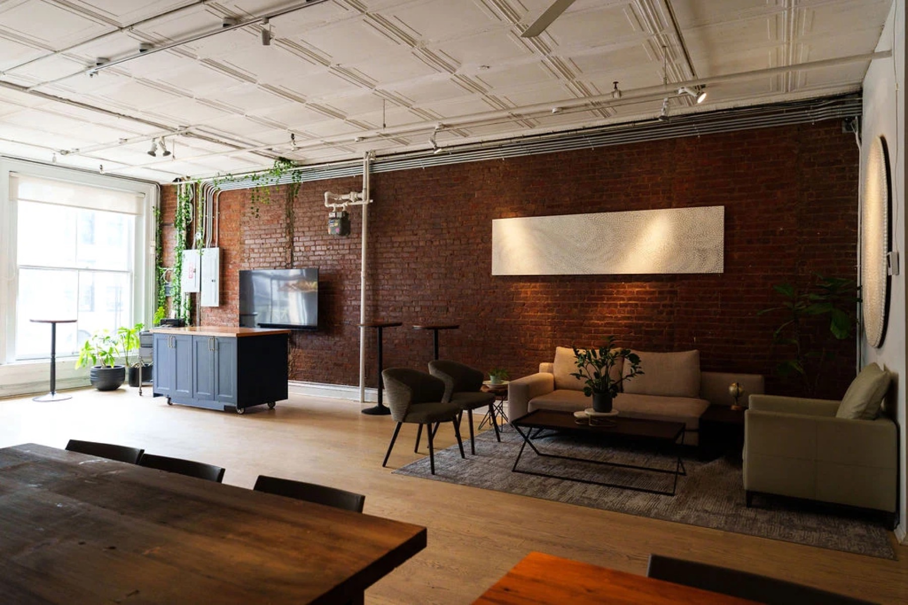 Dining loft with kitchen island, lounge seating and brick wall