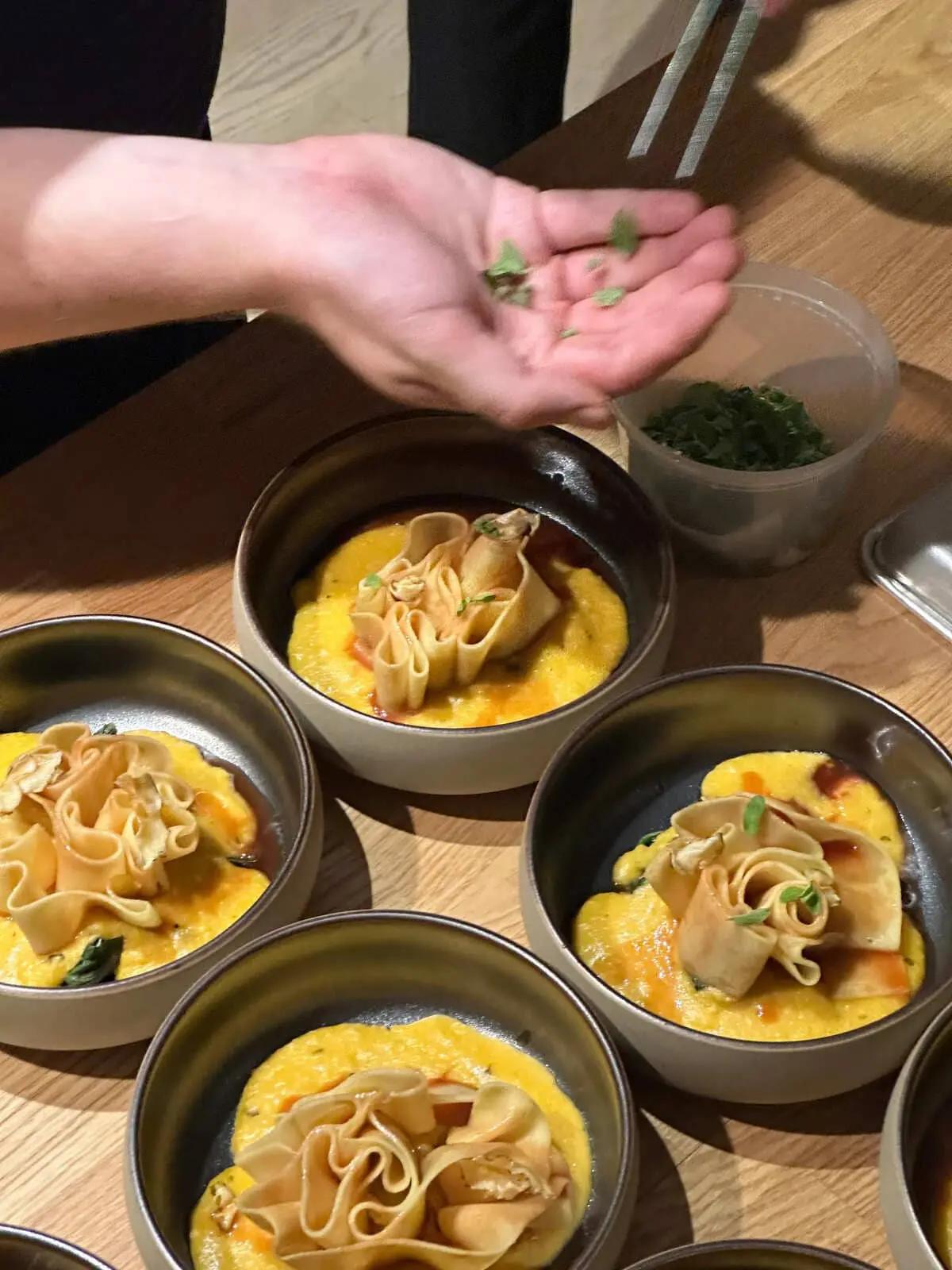 Plated dishes being finished by hand