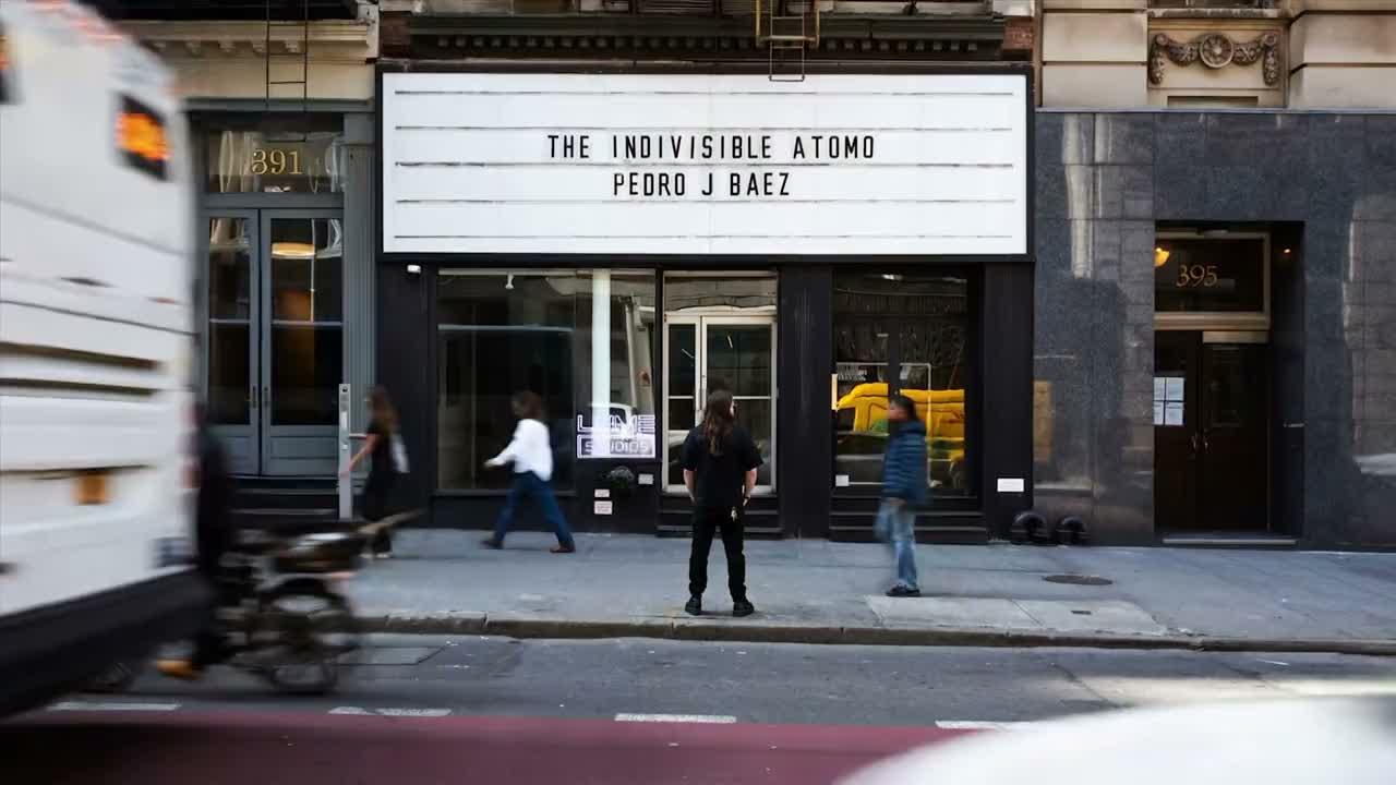 Storefront and marquee with a cyclist passing