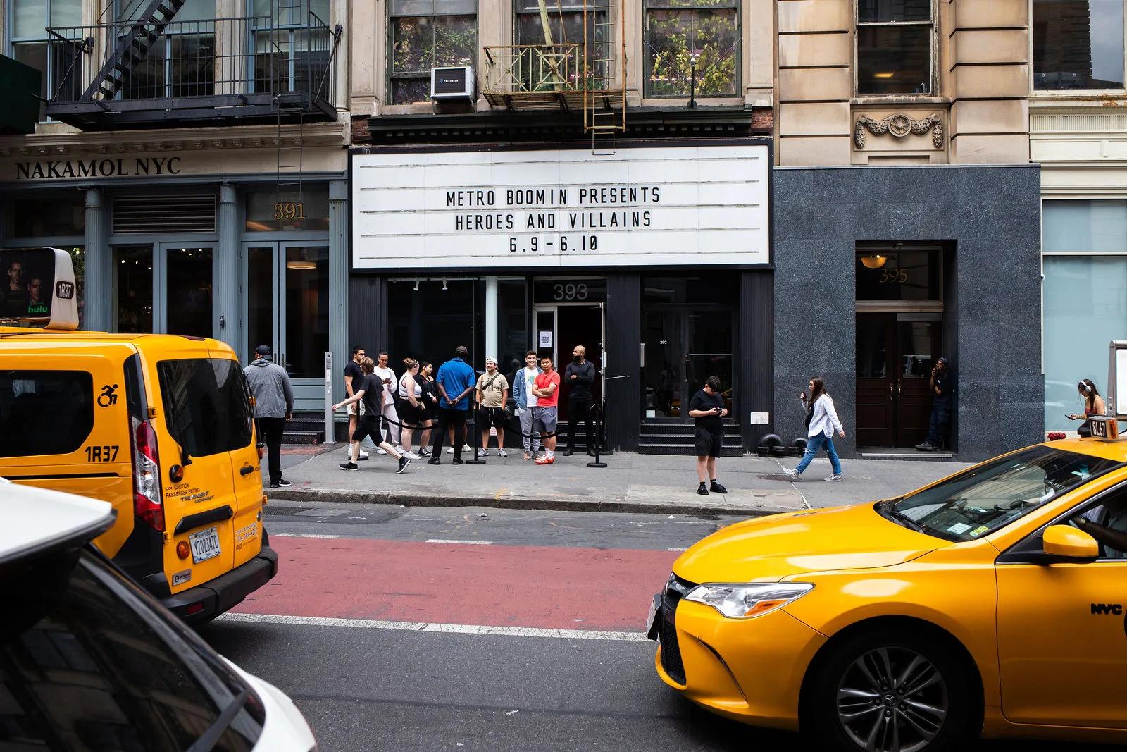 Marquee and storefront framed by Broadway traffic