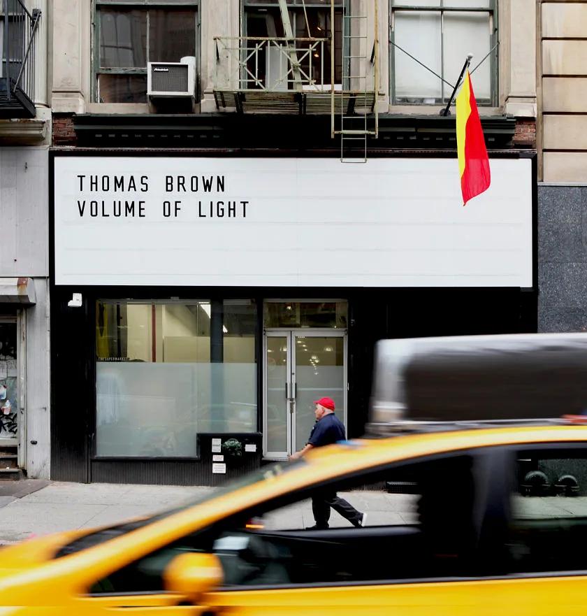 Storefront and marquee from across Broadway, a yellow cab blurring past