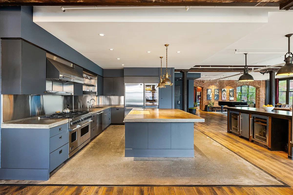Chef's kitchen with blue-grey cabinets, a long island and a professional range
