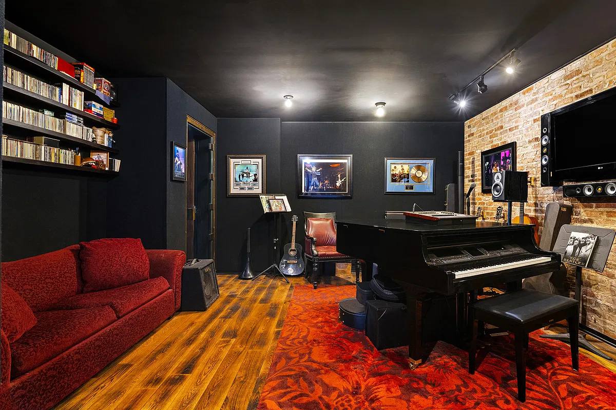 Soundproofed recording studio with a grand piano, red sofa and brick wall