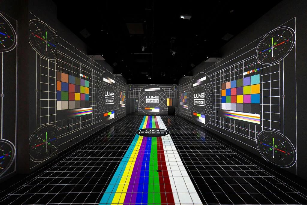 Projection calibration grid across the walls and floor of the empty stage