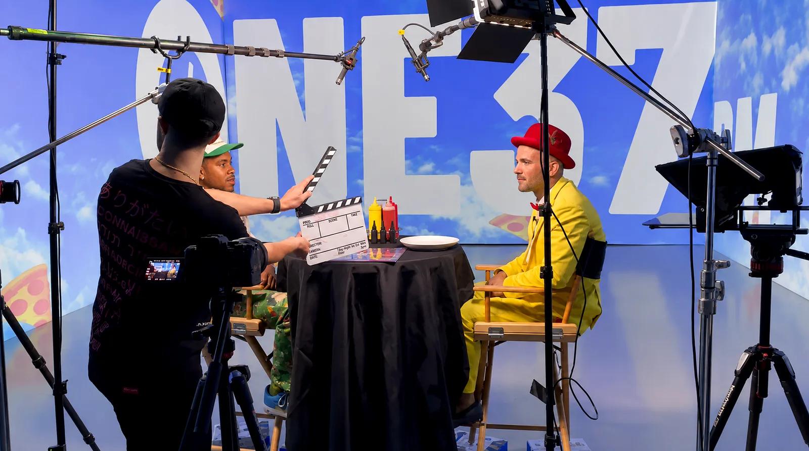 Crew with a clapperboard on a shoot against a projected sky set