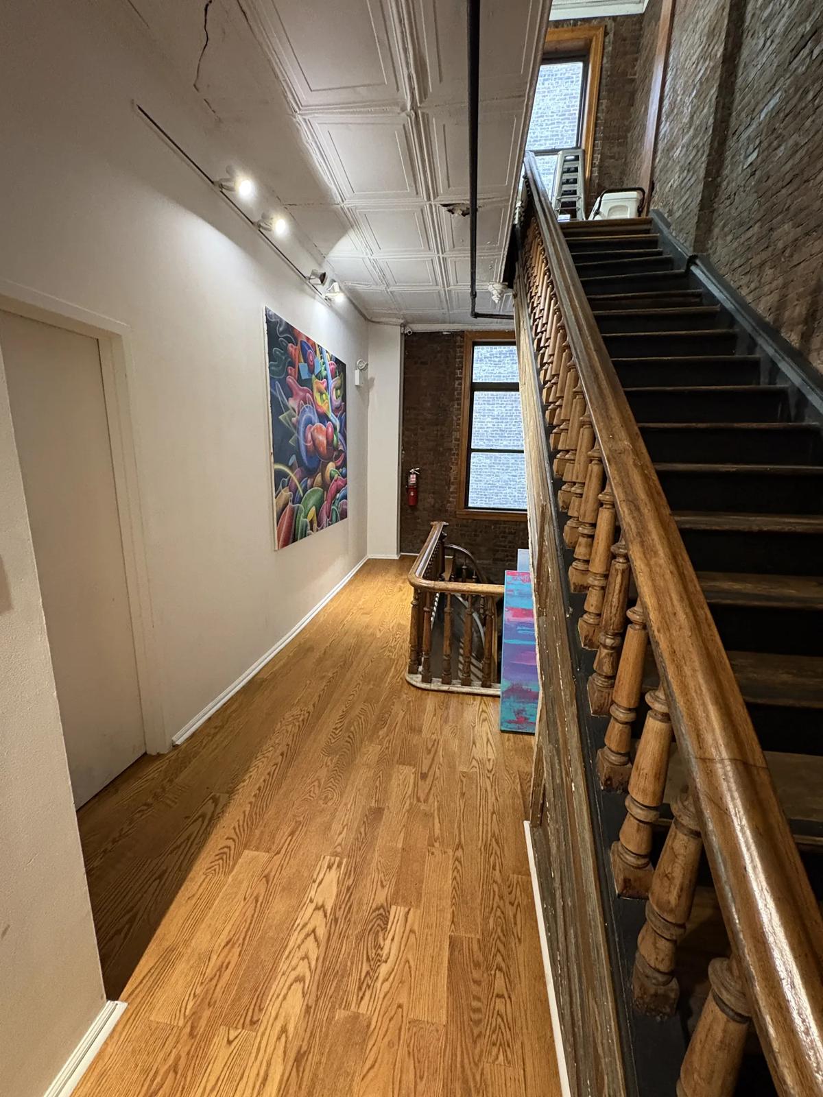 Landing with the stairs rising along exposed brick