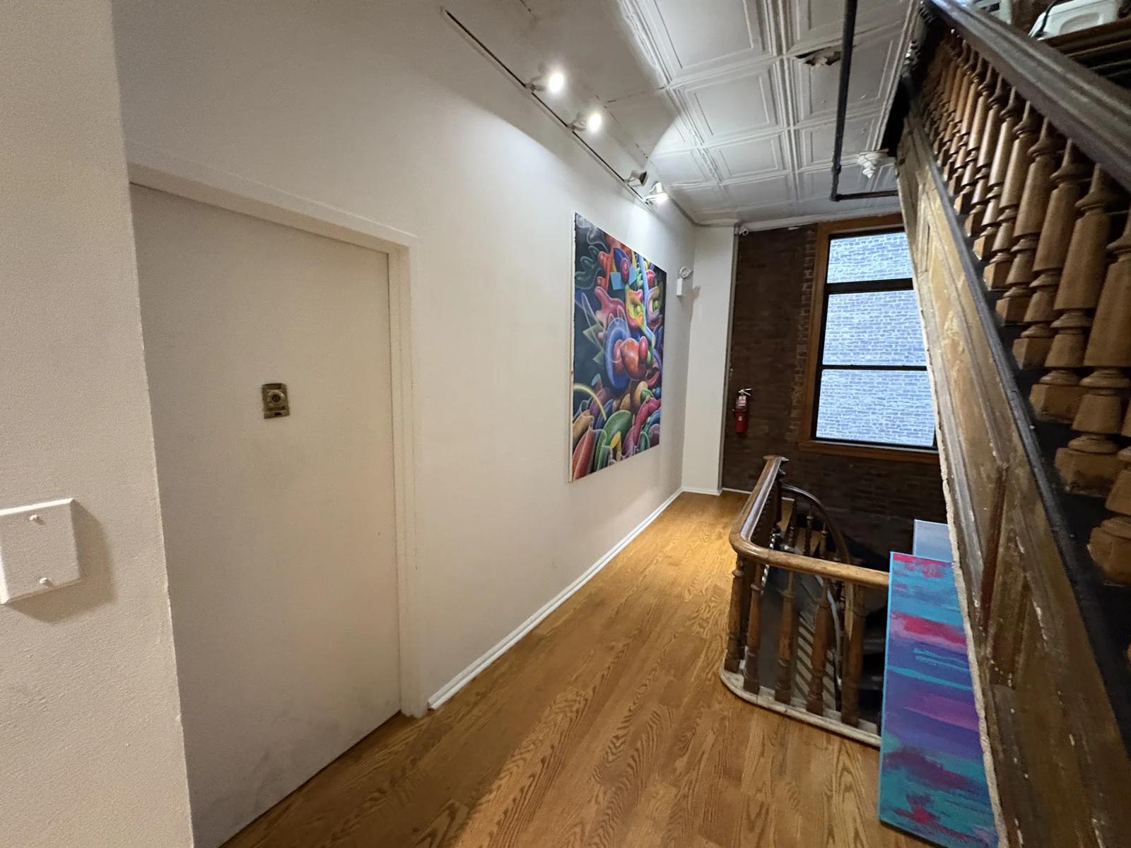 Landing with a window, wood railings and art on the wall
